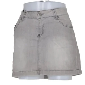 Grå jeanskjol med dragkedjor - Snygg grå jeanskjol i kort modell med klassiska fickor fram och bak samt dragkedjor på bakfickorna. Kjolen har bälteshällor och knappstängning framtill. Perfekt för dig som gillar en enkel men cool stil.