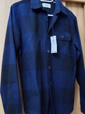 Overshirt / skjortjacka strl S – helt ny - Helt ny med prislapp kvar (nypris ca 349 kr). Snygg mörkblå rutig overshirt – perfekt till höst/vår.  💰 Pris: 120 kr  📏 Storlek: S 🎨 Färg: Mörkblå/rutig  📦 Oanvänd – först till kvarn 💬 Skriv vid intresse!