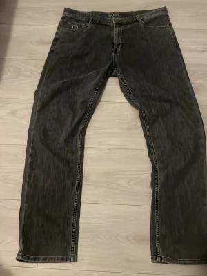 Svarta jeans från BOSS - Snygga svarta jeans från BOSS med tvättad look och raka ben. Klassisk femficksmodell med detaljerade sömmar och metallknappar. Perfekta för dig som vill ha en stilren och modern vibe i garderoben.