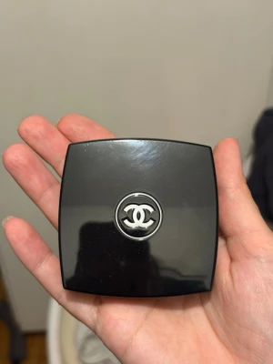 Chanel Joues Contraste Rouge 55 In Love - Chanel Joues Contraste Powder Blush i nyansen 55 In Love. Kommer i en elegant svart kompakt dosa med spegel och ikonisk Chanel-logga. Färgen är en varm persikorosa ton som ger en fräsch och naturlig look. Innehåller 4g puderrouge.