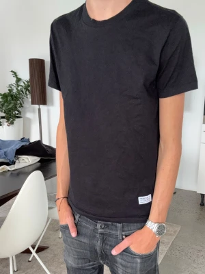 Svart t-shirt från Replay - En stilren svart t-shirt från Replay med rund hals och korta ärmar. T-shirten har en liten Replay-logga på framsidan vid nederkanten och tryck i nacken. Perfekt basplagg i mjukt bomullsmaterial. Passar mindre S