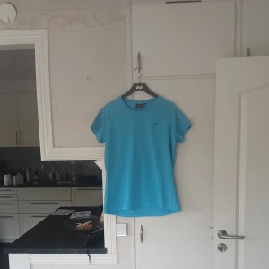 Blå sport t-shirt - En enkel och stilren blå t-shirt med rund hals och korta ärmar. Tillverkad i ett lätt material som passar perfekt för träning eller andra sportaktiviteter. Klassisk passform och diskret logga på bröstet.
