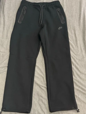 Svarta mjukisbyxor från Nike - Svarta Nike tech byxor nya modellen den är i storlek L passar som M/L, jag själv har M på byxor och den passar bra både för L och M ,den är inte använd mycket jag skulle säga skicken är som ny. Ny pris ligger runt 1200 kr 