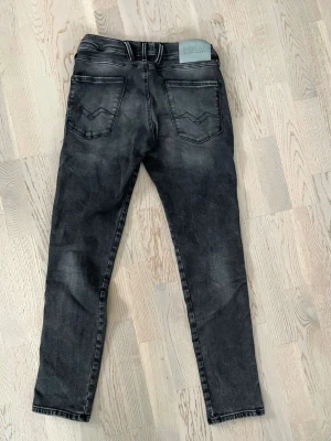 Replay anbass - Säljer ett par svarta Replay jeans med slim fit och klassiska bakfickor med broderad detalj. Jeansen har bälteshällor och en ljusgrå patch med Replay-logga bak i midjan. Snygg tvättad look och passar perfekt till en stilren stil. W29 L30 helt nya utan prislapp