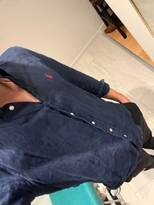 Ralph lauren linneskjorta - Säljer en fet marinblå linneskjorta från Ralph Lauren! Perfekt till sommar och vår☀️🏖️🏝️! Skick: 9/10! Knappt använd! Storlek 18-20 år vilket motsvarar herr S! Skriv vid frågor 👋