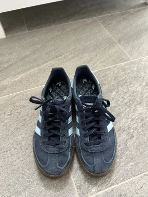 Adidas Spezial sneakers - Säljer ett par Adidas Spezial sneakers i mörkblå mocka med ljusblå ränder med bruna sulor. Storlek 35 1/2 och i jättefint skick. Använd några gånger. Hör av dig eller klicka på köp om du är intresserad !