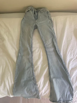 Ljusblå bootcut jeans - Säljer ett par ljusblå bootcut jeans med hög midja och klassiska fem fickor. Jeansen har utsvängda ben och är gjorda i denim. Lite slitna längst ner. I storlek xxs. Pris kan diskuteras😁