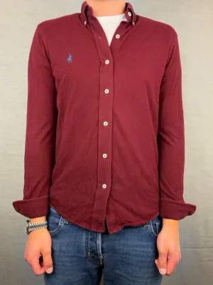 Ralph lauren skjorta vinröd S - Säljer denna fantastiskt snygga ralph lauren skjorta. Riktigt skönt material . Size S. Modellen är 180cm. Bredd 47 längd 63cm! Fint skick, nytvättad och ny strykt så att skillnaden på denna och en ny ska vara minimal! Fraktar samma dag som köp, kan gå ner i pris vid snabb affär! 🤩