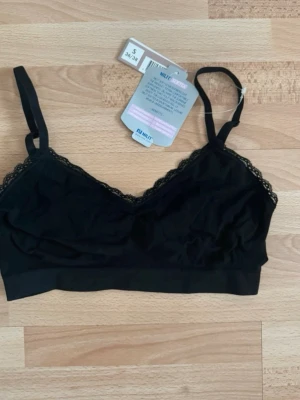 Ny. Svart bralette med spetskant - Svart bralette med smala axelband och dekorativ spetskant längs kuporna. Mjuk och stretchig modell utan byglar, perfekt för en bekväm känsla. Enkel och stilren design som passar till det mesta.