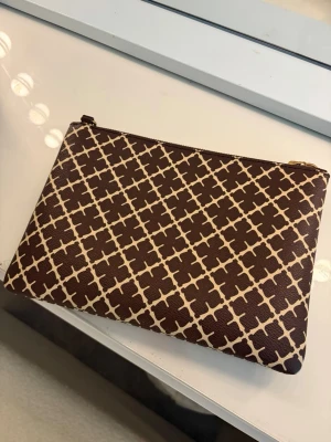 Brun kuvertväska från By Malene Birger - En rymlig och super!! Bra väska från Marlene Birger (köpt på Nelly). Jag har haft denna i 1 vecka, säljer därför denna för vill köpa en modell mindre. (Köpte fel storlek). Så inprincip ny. Det finns en avtagbart band/axelband och påsen följer med såklart.