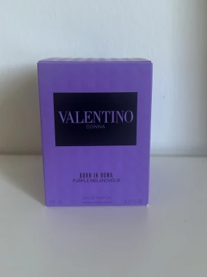 Valentino Donna Born In Roma parfym - Valentino Donna Born In Roma Purple Melancholia Eau de Parfum i en snygg lila förpackning. Doften är elegant och modern, och flaskan rymmer 100 ml. Perfekt för dig som gillar exklusiva och trendiga parfymer.