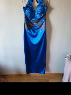 Festklänning - Klänning aldrig använd. satin med guldpaljetter. Öppen rygg. Slits bak. Men den har ingen prislapp och har legat nerpackad i väska.   Kolla gärna  mina andra annonser😊