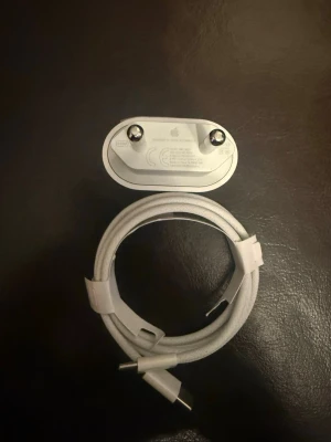 Vit USB-C laddare och kabel - Säljer en vit USB-C laddare med tillhörande kabel. Laddaren har två stift och kabeln är flätad för extra hållbarhet. Perfekt för snabbladdning av mobiltelefoner och andra enheter som stödjer USB-C.