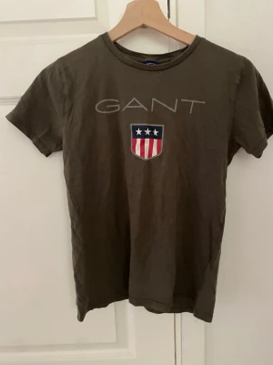 Olivgrön GANT t-shirt med tryck - Snygg olivgrön t-shirt från GANT, storlek 146-152 cm.