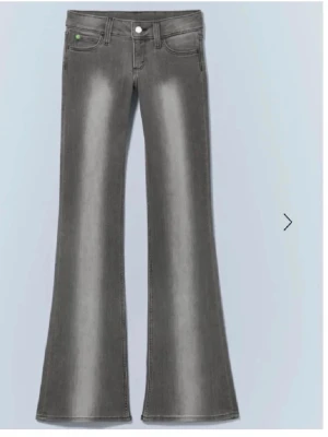 Grå utsvängda jeans  - Snygga grå jeans med utsvängda ben. Klassisk femficksmodell med subtila slitningar framtill och bakfickor. Jeansen har en modern tvätt och är tillverkade i denim med stretch för extra komfort.