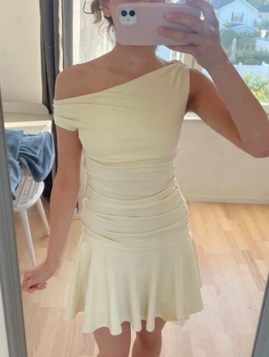 Ljusgul oneshoulder kortklänning - Snygg ljusgul kortklänning med oneshoulder-design och figurnära passform. Säljs för billigare på min vinted: lilycrii💞Endast använd 1 gång