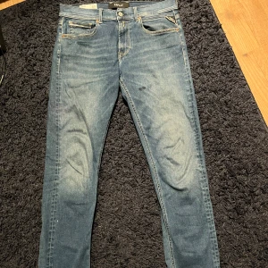 Blå slim fit jeans från Replay - Säljer ett par blå slim fit jeans från Replay med klassisk femficksdesign. Materialet är denim med stretch för extra komfort. Bra skick, inga defekter. Pris kan diskuteras. Kontakta vid frågor.