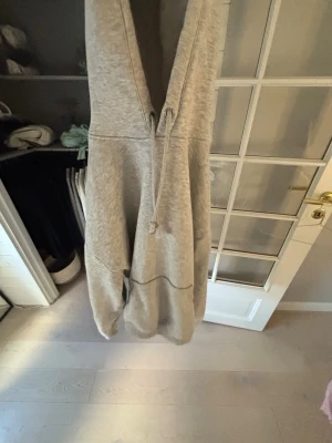 Oversized grå hoodie med huva - En oversized ljusgrå hoodie med stor huva och dragsko. Hoodien e från bik bok i stolen S och e i nytt skick! 