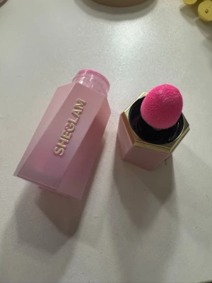  SHEGLAM flytande rouge petal talk - Flytande rouge från SHEGLAM i en snygg rosa förpackning med guldiga detaljer. Kommer med en mjuk, rosa applikator som gör det enkelt att applicera produkten jämnt på kinderna. Perfekt för att ge en fräsch och naturlig look.