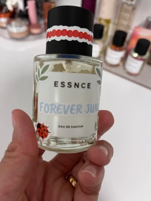 Essnce Forever June Eau de Parfum - Forever June 50 ml från Essnce. Limiterad parfym som finns sommar 2026. Endast testad några gånger. Har satt på en del klistermärken. Se bild för märken och för att se mängden. 