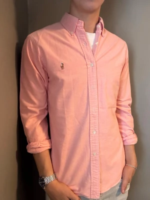 Ralph Lauren skjorta rosa – M slim fit - Säljer denna stilrena och snygga rosa Ralph Lauren skjorta. Skjortan är i mycket bra skick och storlek M slim fit. Perfekt för både vardag och mer uppklädda tillfällen. Har du några frågor? Tveka inte att höra av dig. Allt gott från Deluxe Garderoben ⭐️