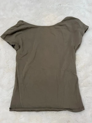 Grön topp med öppen rygg - Säljer en enkel grön topp med öppen rygg från Nelly i strl XXS. 