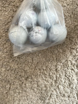 Påse med vita golfbollar - Säljer en plastpåse fylld med flera vita golfbollar. Perfekt för dig som vill fylla på golfutrustningen eller behöver extra bollar till träningen. Bollarna är av standardstorlek och har klassisk golfbollsyta med små gropar.