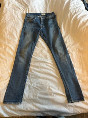 Blå raka Tiger of Sweden jeans  - Snygga blå Tiger of Sweden jeans med raka ben och klassisk femficksdesign. Jeansen har ljus tvätt och subtila slitningar framtill samt kontrastsömmar. Perfekta för en avslappnad och trendig look.