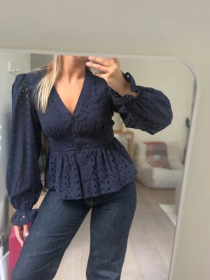 Marinblå broderad blus  - Marinblå broderad blus med djup v-ringning och knappar framtill. Saknar lapp med storlek men passar S/M. Använd men i fint skick!🩵