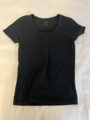2- pack Svart t-shirt från Newbody - En klassisk svart t-shirt från Newbody med rund halsringning och korta ärmar. Tillverkad i mjuk bomull med lite elastan för extra stretch och skön passform. Perfekt basplagg till garderoben.