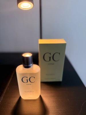 GC one parfym från Giverny - GC one från Giverny är en parfym i en stilren, frostad glasflaska med silverfärgad kork. Flaskan har en enkel och modern design med svart text. Förpackningen är ljusgul och matchar flaskans eleganta look.