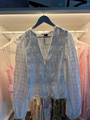Vit blus med knappar och rynk - Säljer en vit blus från Gina, aldrig blivit använd så den ser helt ny ut💗
