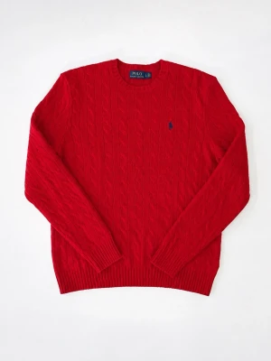 Röd kabelstickad tröja Polo Ralph Lauren - Snygg röd kabelstickad tröja från Polo Ralph Lauren med rund halsringning och diskret blå logga på bröstet. Tröjan har långa ärmar och ribbade muddar vid ärmslut och nederkant. Perfekt för dig som vill ha en klassisk och stilren look.