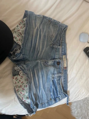 Blå jeansshorts från Fishbone - Säljer ett par ljusblå jeansshorts från Fishbone, bältesögglan har lossnat som man kan se men det går enkelt att fixa 