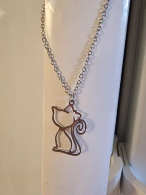 Halsband söt katt - Snyggt halsband i rostfritt stål med kattmotiv och rosett, perfekt för födelsedagar, årsdagar och formella evenemang. Kedja 40 cm + 5 cm. Berlock 2,7 cm hög. Bredd 1,6 cm. Inkl kedja.