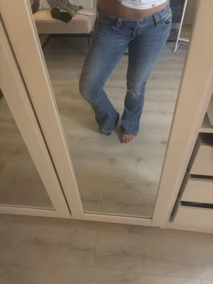 Bootcut jeans lågmidjade  - Jeans från gina tricot, vingar på fickorna. Hål på jeansen. 