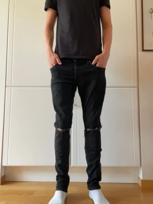 Jeans - Tja! Säljer dessa svarta jeans med hål vid knäna. Hör gärna av dig vid frågor eller funderingar.