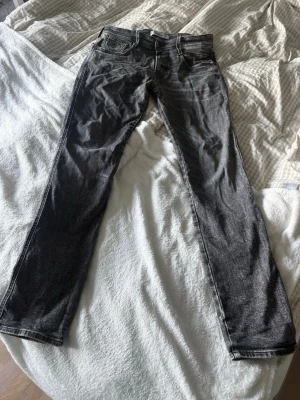 Svarta raka jeans med kontrastsömmar - Säljer ett par svarta replay jeans med raka ben och kontrastsömmar. . Materialet är denim och färgen är tvättad svart med lätt slitning. 