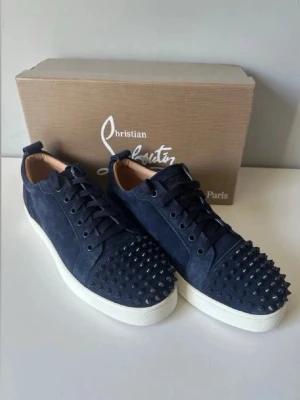  Louboutin skor  - Säljer dessa feta loubs i färgen mörkblå, skorna har silvriga taggar och den välkända röda sulan med vit ram. 