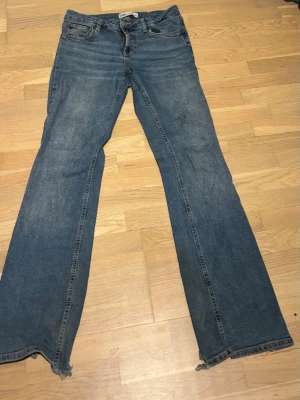 Blå bootcut jeans  - Ett par blå bootcut jeans. Klassisk femficksmodell i mjuk denim med lätt tvättad look. Perfekta för en avslappnad och trendig stil.