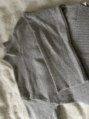 Grå stickad polo tröja - Säljer denna super mysiga stickade polo tröjan från gina tricot. perfekt till hösten / kyligare dagar. jätte fint skick utom att det finns ett litet hål i vänstra ärmen, men inget märkvärdigt alls!