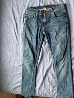 Blå slim fit jeans med slitningar - Säljer ett par riktigt sköna nudie jeans. Jeansen har en stretchmodell och sitter därför väldigt skönt. Nästintill aldrig använda eftersom det var för små när jag köpte de…..