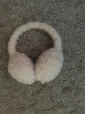 Vita fluffiga öronmuffar Gina - Söta trendiga öronmuffar i vit fluffig fuskpäls. Perfekta till vintern! Köpta i vintras och dom är knappt använda, precis som nyskick - därför dyrare pris. 