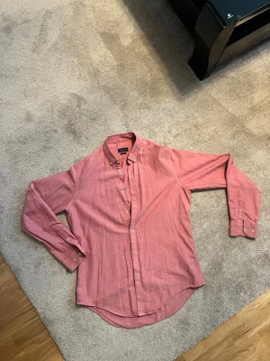 Rosa skjorta från Zara Man slim fit - Pris diskuteras privat! Slim fit L. Säljer en rosa långärmad skjorta från Zara Man i slim fit-modell. Skjortan har klassisk krage, vita knappar och är tillverkad i bomull. Perfekt för dig som gillar en stilren och enkel look.
