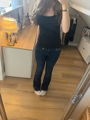 Mörkblå bootcut jeans - Snygga mörkblå bootcut jeans med low-mid rise. De är lite slitna vid ena byxbenet som man kan se på bilden, annars i bra skick!