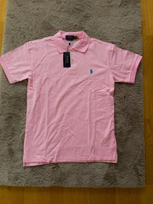Ralph Lauren piké - Mycket fin rosa Ralph lauren pike. Oanvänd. Storlek M