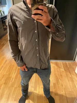 Mörkgrå skjorta Ralph Lauren skjorta - Ralph Lauren skjorta. Skick: bra, litet slitage på ryggen men inget som påverkar användning. Storlek:M Hör av dig om du har några frågor😁Modell: 178cm 70kg