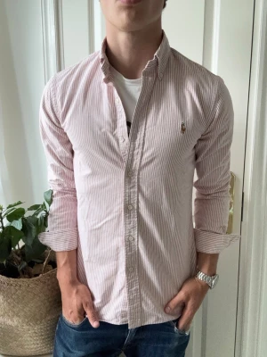 Ralph lauren skjorta randig  - Ralph lauren skjorta randig, vit / rosa randig. Sjukt snygg, passar perfekt på mig. Inga defekter! Modellen i bilderna är 180 cm 75 kg och bär Storlek S , Kom med frågor! 🌟 (Kan gå ned i pris vid köp av paket 😉) 