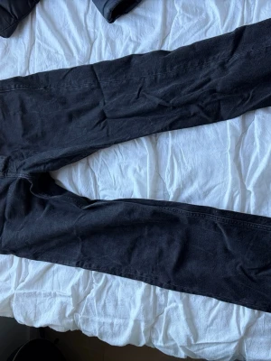 Svarta loose fit jeans 28/30 - Säljer ett par svarta loose fit jeans från Jack and Jones med raka ben och klassisk femficksmodell. Jeansen har en avslappnad passform och är tillverkade i denim. Perfekta för en chill och trendig look.