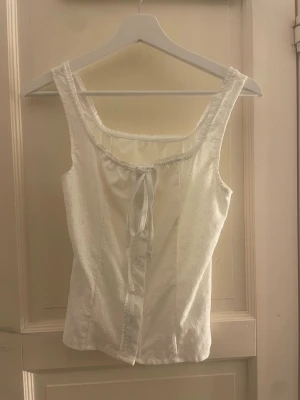 Vit broderad linnetopp med knyt - Söt vit linnetopp med broderade detaljer och knyt framtill. Toppen är från SHEIN o är skit snygg att aningen bara ha i skolan eller lite finare tillfällen 💕